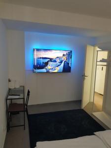 Zimmer mit einem an der Wand hängenden TV in der Unterkunft Modern apartment cologne in Köln