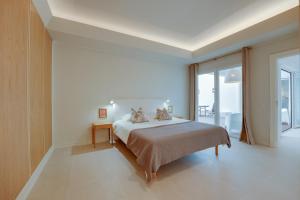 a white bedroom with a bed and a balcony at CICAS VILLA in Albufeira +59 photos