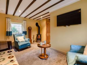 a living room with a tv and two chairs and a table at 1 Bed in Waterfall 89733 in Waterhouses