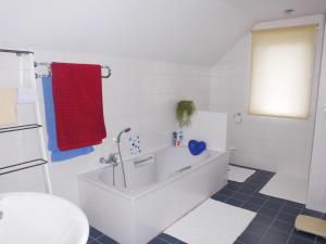 イーペルにあるChez Paulのバスルーム(白いバスタブ、赤いタオル付)