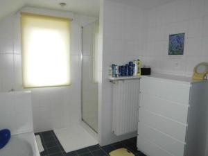 a white bathroom with a shower and a sink at Chez Paul in Ieper