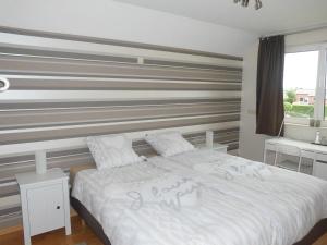 a bedroom with a bed with a striped wall at Chez Paul in Ieper