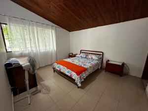 a bedroom with a bed in a room with a window at Finca Bendita Caña in Villeta