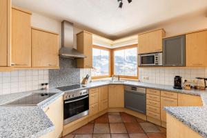 拉迪斯的住宿－Jägerlodge Apartments，厨房配有木制橱柜和炉灶烤箱。