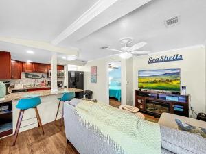 a living room with a couch and a tv at Island Hideaway steps to beach dock Bridge St in Bradenton Beach