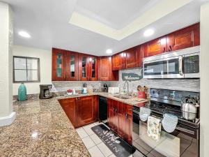a kitchen with wooden cabinets and a stove top oven at Island Hideaway steps to beach dock Bridge St in Bradenton Beach