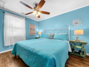 a blue bedroom with a bed and a ceiling fan at Island Hideaway steps to beach dock Bridge St in Bradenton Beach