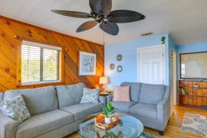 ein Wohnzimmer mit einem Sofa und einem Deckenventilator in der Unterkunft Waterfront Cedar Key Duplex Home with Private Dock! in Cedar Key
