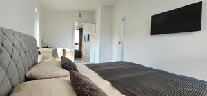 a living room with a couch and a flat screen tv at Lighthouse Apartment Šventosios Vartai in Palanga