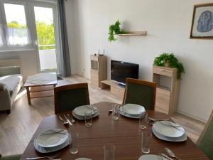 a living room with a table and chairs and a television at Neue Ferien Monteurwohnung mit 3 Schlafzimmer 22 in Wefensleben