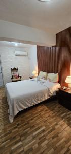 1 dormitorio con 1 cama grande y suelo de madera en Hotel Cana Palma Zona Colonial en Santo Domingo