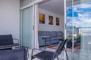 een woonkamer met een bank en een tafel en stoelen bij Zeno stay - No Loadshedding in Kaapstad