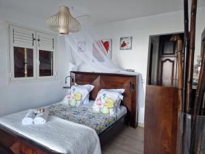 een slaapkamer met een houten bed met kussens bij Villa Lidoam vue mer imprenable in Le Vauclin