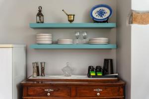 a shelf with plates and glasses on top of a dresser at Feel Filoti in Philotium +52 photos