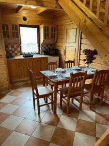 eine Küche mit einem Tisch und Stühlen in einer Hütte in der Unterkunft Roby 45 in Mrzeżyno