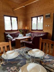 ein Esszimmer mit einem Tisch mit Tellern darauf in der Unterkunft Roby 45 in Mrzeżyno