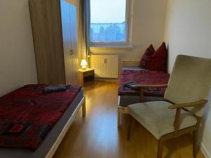 a bedroom with a bed and a chair and a window at Neue Ferien Monteurwohnung mit 3 Schlafzimmer 22 in Wefensleben