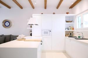 a white kitchen with white cabinets and a sink at Senza's Cycladic Home in Marpissa , Paros in Kampos Paros