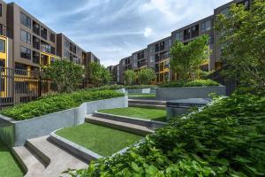 a courtyard with stairs and grass and buildings at PRIME TOWN Phuket Resort & Wellness in Ban Rangeng