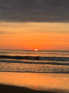 una puesta de sol en una playa con el océano en Los Corales en Máncora