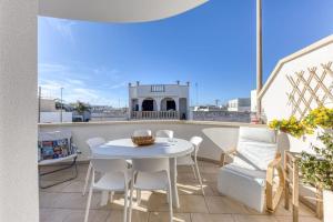 a white table and chairs on a balcony at Casa Dandari in Torre San Giovanni Ugento