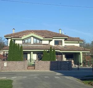 a large white house with a fence in front of it at Apartmány IVETA in Podhájska