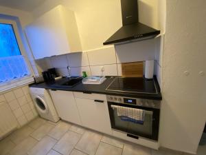 a kitchen with a stove top oven next to a sink at Neue Ferien Monteurwohnung mit 3 Schlafzimmer 22 in Wefensleben