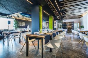 a dining room with tables and white chairs at JO Hotel in Marano Lagunare