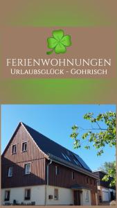 a barn with a green clover on the roof at Ferienwohnungen Urlaubsglück in Kurort Gohrisch