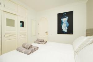 a white bedroom with two towels on a bed at Casa Federico in Puerto del Carmen +29 photos