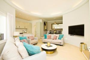 a living room with white furniture and a flat screen tv at Casa Federico in Puerto del Carmen