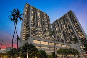 zwei hohe Gebäude in einer Stadt mit Palmen in der Unterkunft 19th Floor Condo with Lanai & Sea Views - FREE Parking! home in Honolulu