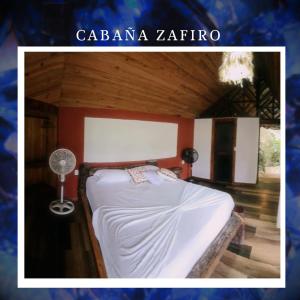 - une chambre avec un lit et un ventilateur dans l'établissement EcoHostal Rio Piedra, à El Zaino
