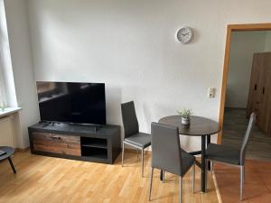 a living room with a table and a flat screen tv at Innenstadtoase im Herzen Torgelows in Torgelow