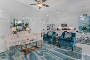 een woonkamer met een bank en twee stoelen bij Serene Canal Views, Paddle Board, Bicycles, Heated Pool and Spa - Villa The Great Escape in Cape Coral
