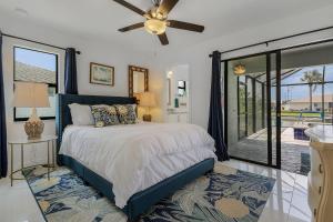 een slaapkamer met een bed en een plafondventilator bij Serene Canal Views, Paddle Board, Bicycles, Heated Pool and Spa - Villa The Great Escape in Cape Coral +42 foto's