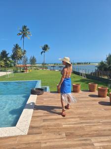 uma mulher de vestido azul ao lado de uma piscina em Villa Garcez em Jaguaripe