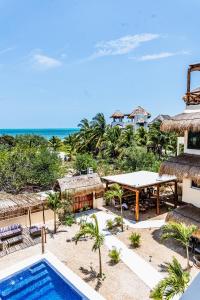 a view of a resort with a swimming pool and the ocean at Atenea Holbox in Holbox Island