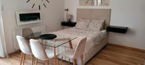 a bedroom with a bed and a glass table and chairs at Apartament MIODOWY przy plaży in Krynica Morska