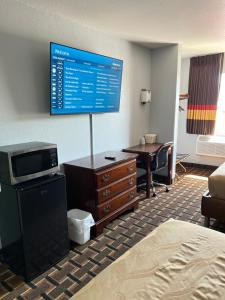 um quarto de hotel com uma secretária e um monitor na parede em Americas Best Value Inn and Suites Albemarle em Albemarle