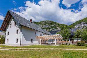 a white house with a solar roof and a lawn at Domačija Log v Bohinju in Bohinjska Bistrica +85 photos