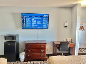 um quarto com uma cama e um monitor na parede em Americas Best Value Inn and Suites Albemarle em Albemarle