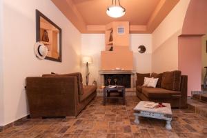 a living room with two couches and a fireplace at Villa Araxovoli in Palaiochóra