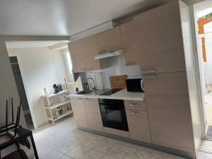 a kitchen with wooden cabinets and a stove top oven at kaon nil in Gerzat