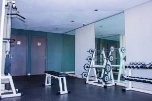 een fitnessruimte met een spiegel, een bank en gewichten bij Zeno stay - No Loadshedding in Kaapstad
