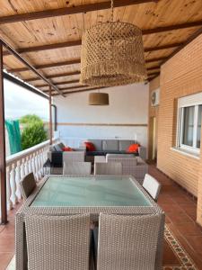 eine Terrasse mit einem Tisch, Stühlen und einem Kronleuchter in der Unterkunft Un sueño en Toledo II, al lado de Puy du Fou in Argés
