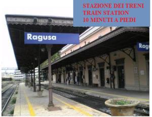 a train station with a blue sign at a train station at Gli Iblei di Montalbano in Ragusa