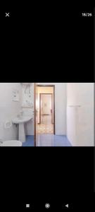a white bathroom with a sink and a toilet at Casa Melina e enzo in Agnone Bagni