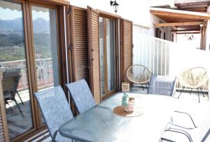 a table and chairs on a balcony with a view at Samos Holiday Home in Mesaíon Karlovásion