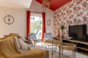 sala de estar con sofá, sillas y TV en Terre Urbaine en Lorient